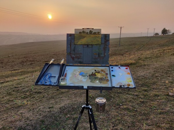 Landscape before sunset painting on easel